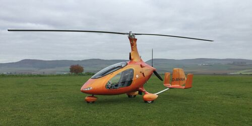 Orangener Gyrokopter auf Gras