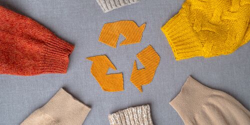Recycling Symbol auf Stoff mit Kleidung drumherum