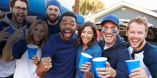 Junge, lachende Menschen mit blauen Plastikbechern