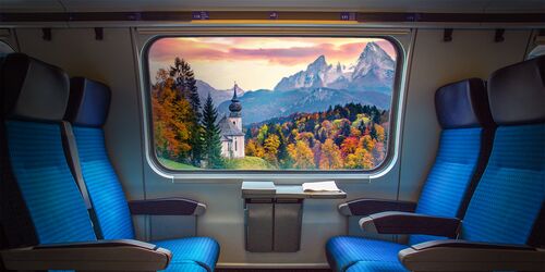 Vierersitz im DB Regio Zug mit Blick aus dem Fenster auf Kirche und Berge