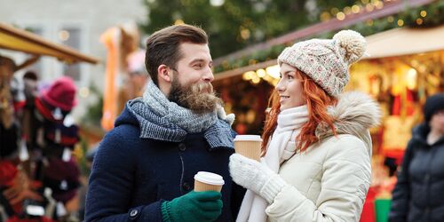 Paar auf dem Weihnachtsmarkt mit Glühwein