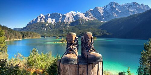 Wanderstiefel vor See und Bergpanorama