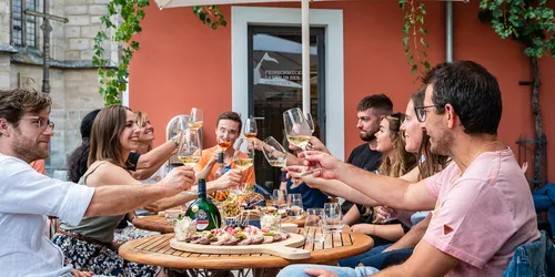 Gesellschaft beim Essen die sich zuprosten