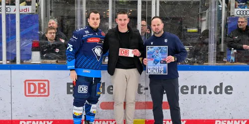 Ein Eishockeyspieler bekommt den Spieler des Monats-Preis überreicht