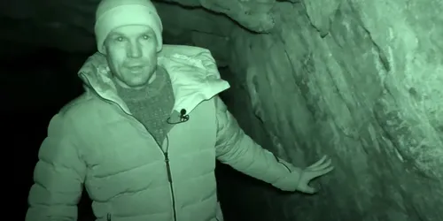 Mann ist in einer Höhle durch ein Nachtsichtgerät sichtbar