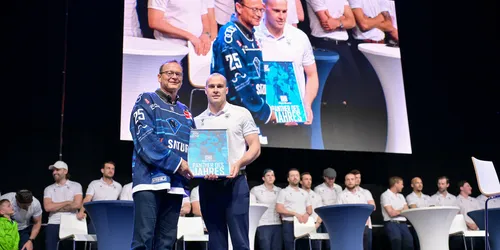 Man sieht einen Eishockeyspieler der eine Auszeichnung zum Spieler des Jahres bekommt