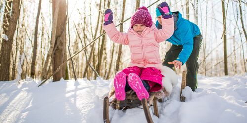 Zwei Kinder mit einem Schlitten im Schnee