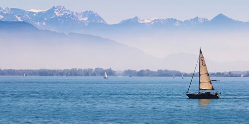 Segelboot auf See mit Bergpanorama