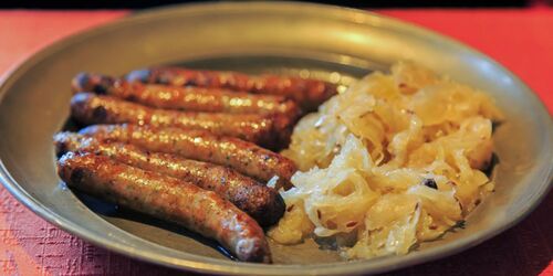 Teller mit Sauerkraut und kleinen Bratwürsten