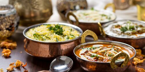Kupfertöpfe mit Reis und indischen Gerichten