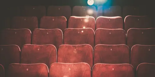 Mehrere Reihen von braunen Theaterstühlen aus Holz