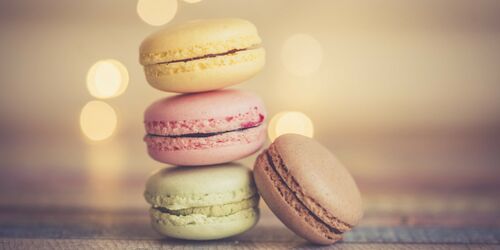 Drei bunte, aufeinandergestapelte Macarons mit einem Macaron daneben