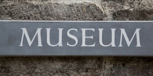 Graues Schild mit der Aufschrift Museum