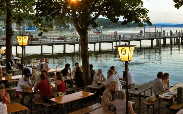 Blick auf Menschen im Biergarten Herrsching mit See im Hintergrund
