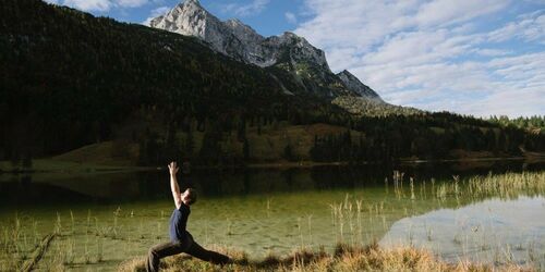 Bergpanorama, See und Person, die Yoga macht